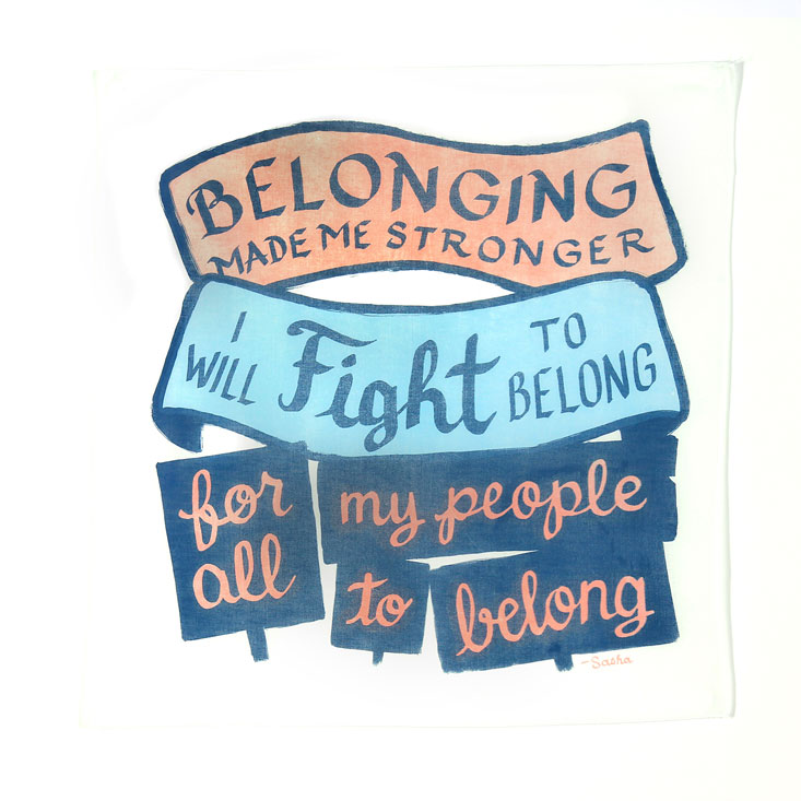 white bandanna with salmon, light blue and navy blue printing of banners and protest signs bearing the text: Belonging makes me stronger. I will fight to belong, for all my people to belong. —Sasha
