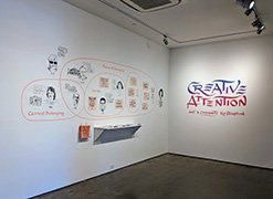 Installation view of a gallery with a Venn diagram with portraits and calligraphy on the left, and a title wall in calligraphy with the title of the exhibition, Creative Attention