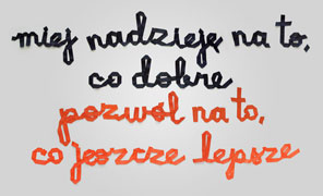 ribbons sewn to spell 'miej nadzieję na to, co dobre, pozwól na to, co jeszcze lepsze' which means 'hope for good, allow for even better' in Polish. it's in blue and orange grosgrain ribbon