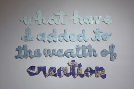 wall installation of ribbon spelling 'what have i added to the wealth of creation'. most of the words are in shades of blue grosgrain; 'creation' is sewn in blue with one face as 1920s chinese embroidered ribbon.