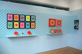 Installation view: from left to right: Flag Snowflakes and Plates series, Hankies, 2009–10, Edition of two embellished handkerchieves: fluorescent handkerchiefs, place mats, thread, wood, 18 x 18 x 2 inches / 46 x 46 x 5 cm each; This Too Shall Pass, 2010, Edition of three papercut collages: paper, calendars, adhesive, customized rabets and frame, painted shelf, 48 x 10 x 12 inches / 1.2 m x 25 cm x 30 cm 