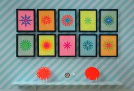 Flag Snowflakes series, 2010, stick-on flags on neon paper, 8.5 x 11 inches / 21.5 x 30 cm; Plates #4, 6, 3, 2010, from an edition of six decorative plates: stickers, labels, plateholders, custom acrylic stands, painted shelf, 72 x 8 x 14 inches / 1.8 m x 20 cm x 36 cm