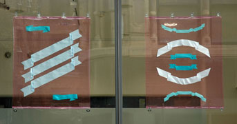 transparent pink vinyl with blue ribbons installed on the windows of the storefront gallery