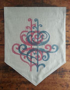 a neutral-colored banner with the bottom cut like a triangle. it is overprinted with a floral design in blue and pink. the designs are offset horizontally.