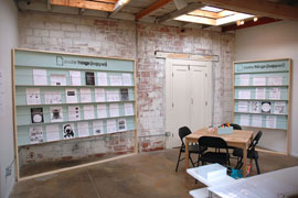 Make Things (Happen), installation view of display units holding 41 activity sheets, plus work table with art supplies. Interface Gallery, Oakland, CA.