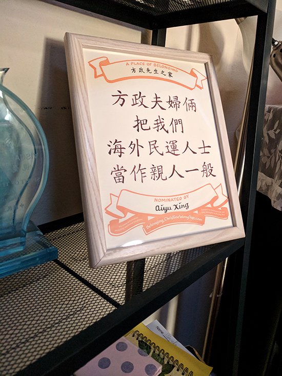 A certificate on a wire shelf alongside an award made of plexiglass. The certificate is in Chinese. 那個地方是中國民主黨灣區黨主席方政先生的家裡，方先生把我們這些海外民運人士當成家人一樣的關心。