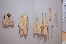 Garments hanging on the wall. They are sewn from cotton duck canvas, with a light blue and green pattern.