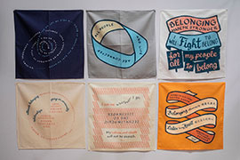 6 colorful bandanas with lettering with quotes about belonging screenprinted on them.