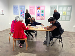 participants engaging the activities at a table/work station and viewing the art on the walls