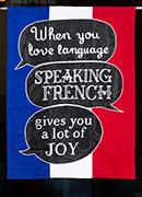 Cartoon speech bubbles on tricolor with the text, When you love language, speaking French gives you a lot of joy.