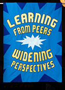 Banner in blue and yellow sparks with the text, learning from peers, widening perspectives.