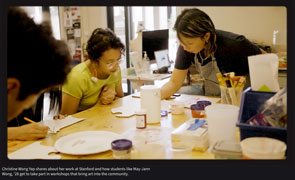 video still with the artist and participating painter painting in an art studio